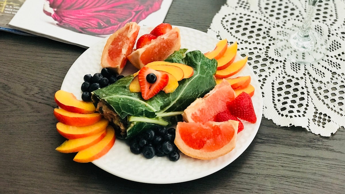 fruits on white plate near books